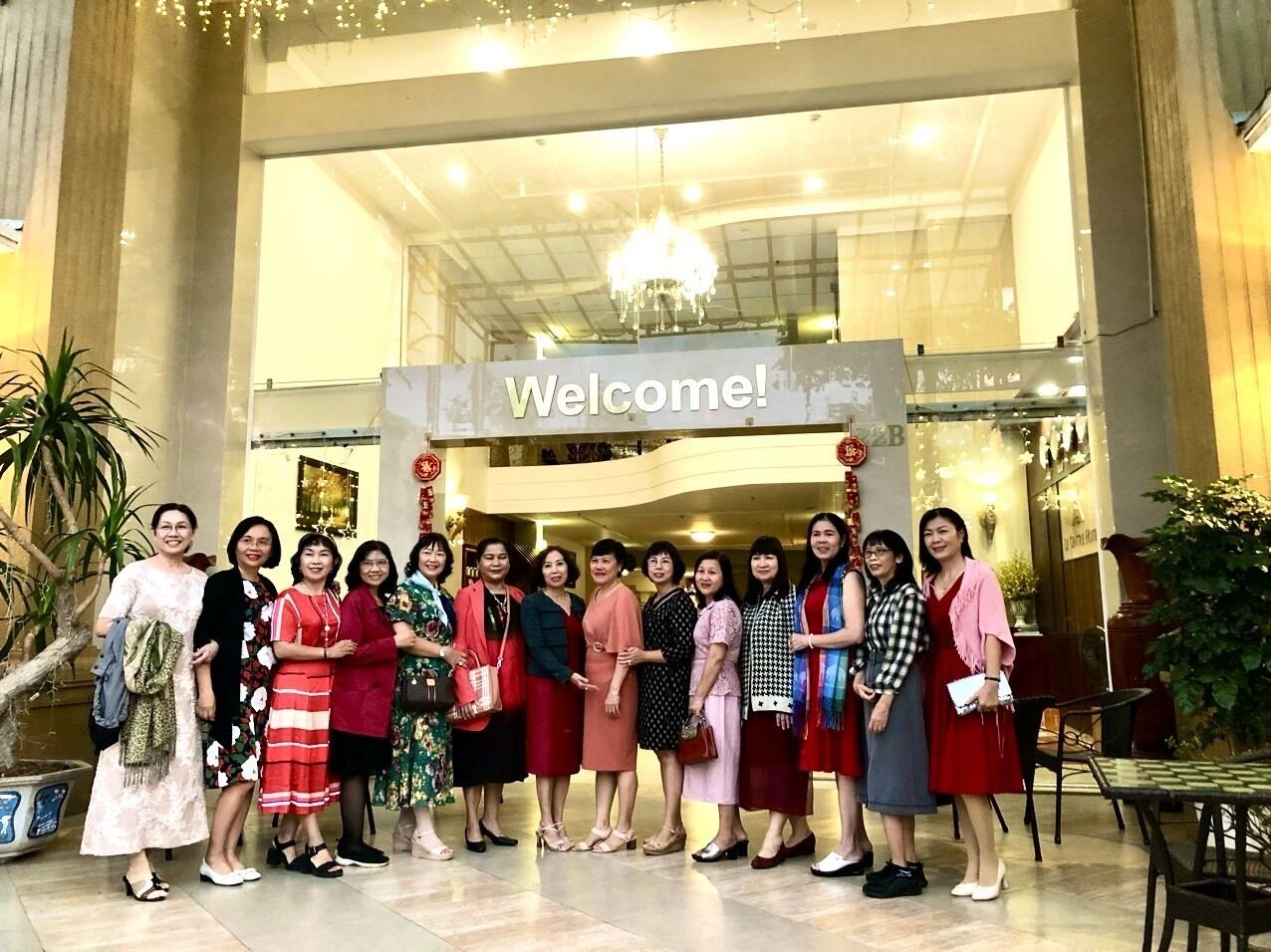 Un grup de persones al vestíbul, amb un cartell que diu 'Welcome!'.