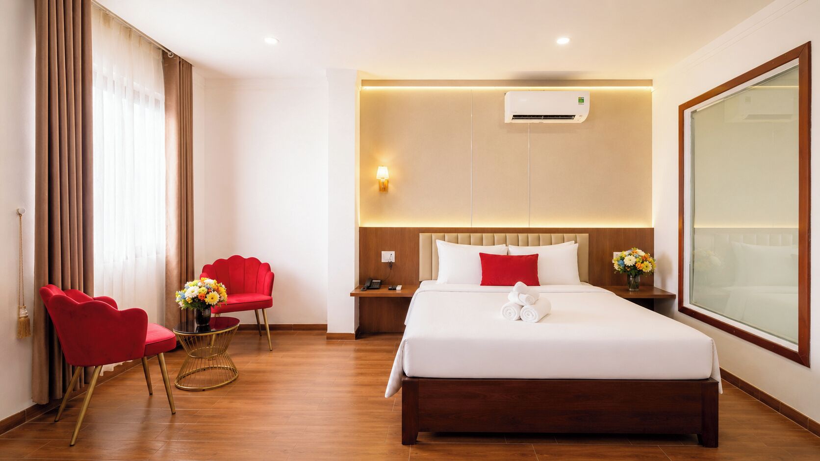 Una habitación de hotel con una cama grande, un escritorio, una silla y un ventanal.