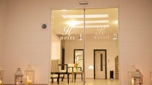 A hotel entrance with a reception desk, chairs, and a sign reading "H HOTEL KANALI". - Hotel Kanali (Preveza)