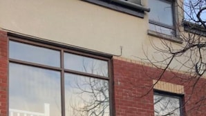 A two-story building with large windows and a brown door. - City Central Townhouse by BHR Apartments (Belfast)