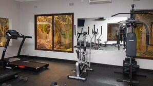 A gym with a treadmill, elliptical, and weight machines. - Sherbourne Lodge (Kitwe)