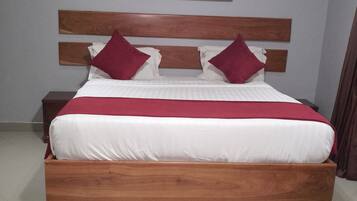 Une chambre à coucher avec un lit en bois, du linge de lit blanc et un plaid rouge.