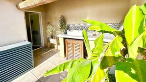 A patio area with a wooden pergola, a tiled backsplash, and potted plants. - Home 12 "les Vignes" (Châteauneuf-du-Pape)