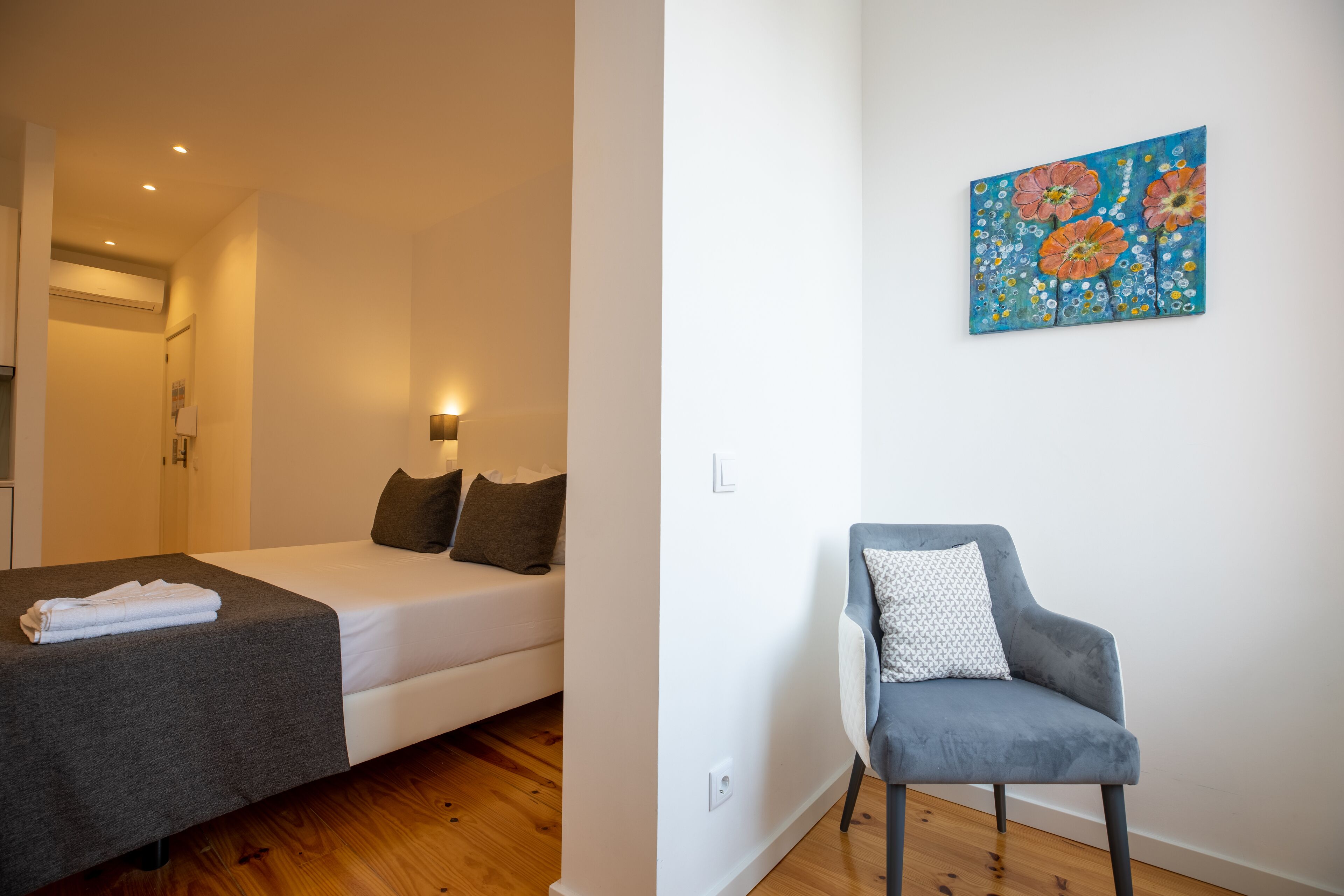 Une chambre moderne avec un lit, une table de chevet et une chaise.