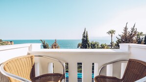 A balcony with two wicker chairs facing a clear blue sea and distant mountains. - Royal City Hotel (Antalya)