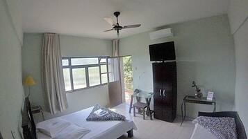 A bedroom with a bed, a desk, a chair, a wardrobe, and a ceiling fan.