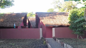 Um jardim com um caminho que leva a um edifício com telhado de palha.