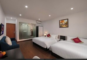 A hotel room with two beds, a sofa, a glass partition, and a painting on the wall. - Hanoi Aria Central Hotel & Spa (Hanoi)