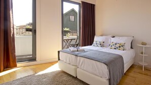 A bedroom with a bed, a small bedside table, a window with curtains, and a view of the outside. - MyStay Porto Bolhão (Porto)