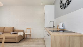 Una cocina moderna con encimera de madera, un lavamanos y un hervidor.