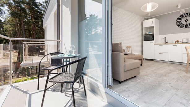 A modern apartment with a balcony, a dining area, a kitchen, and a living room. - Villa Ula Apartament (Rewal)