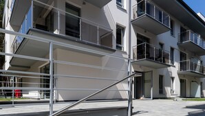 A multi-story building with a modern design, featuring a staircase with metal railings leading to an entrance. - Villa Ula Apartament (Rewal)