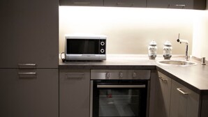 A kitchen with a microwave, oven, and sink. - Il Genovino (Genoa)