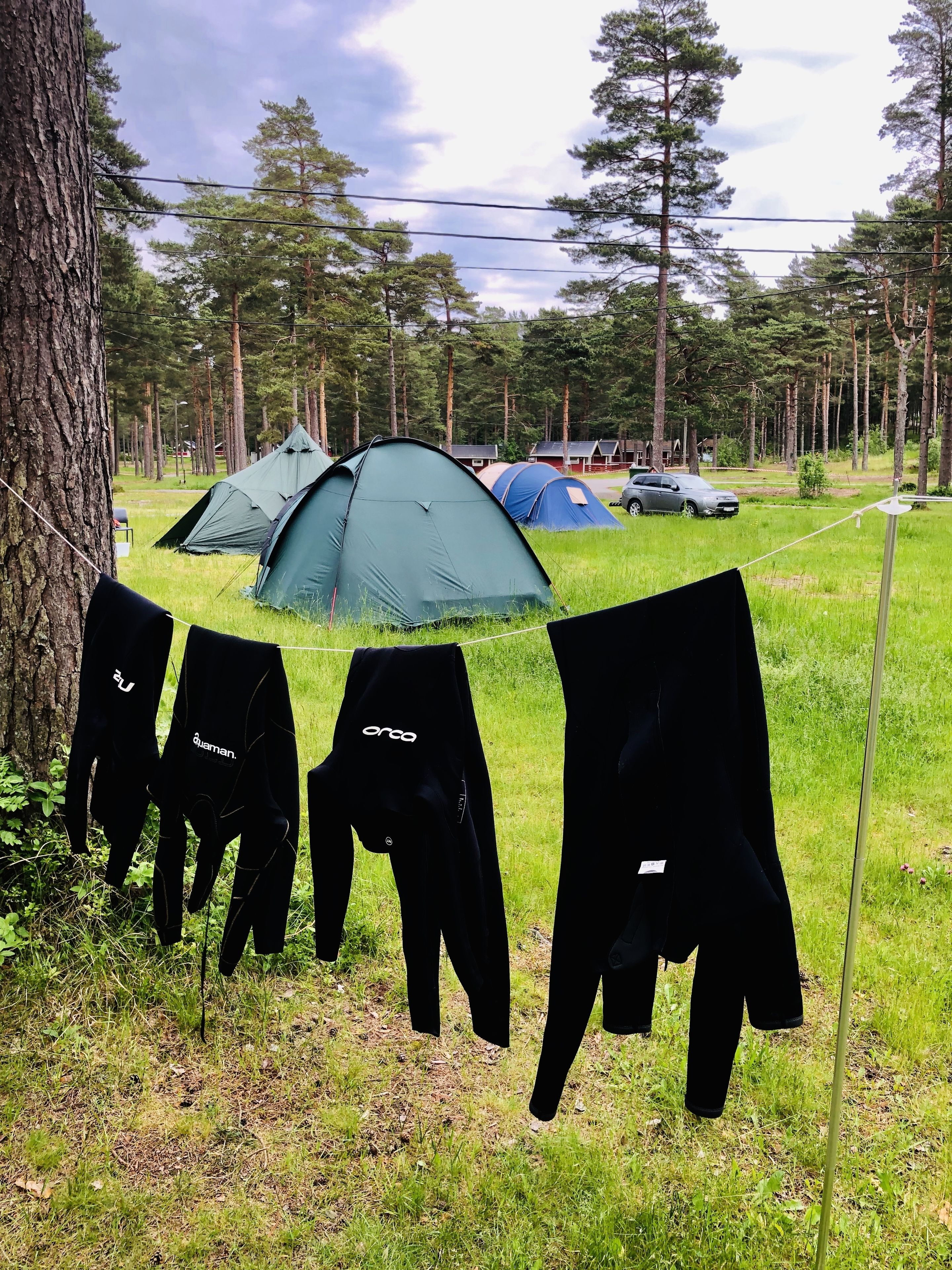 A campsite with tents and a car parked nearby.