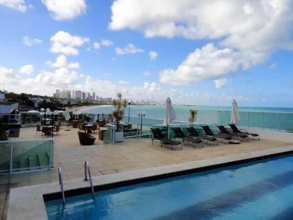 Piscine extérieure, parasols de plage, chaises longues