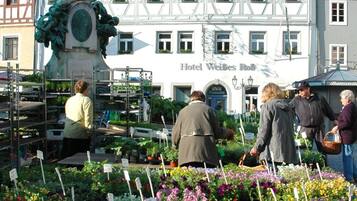 Ein Blumenmarkt voller bunter Blumen mit einem hohen Denkmal in der Mitte.