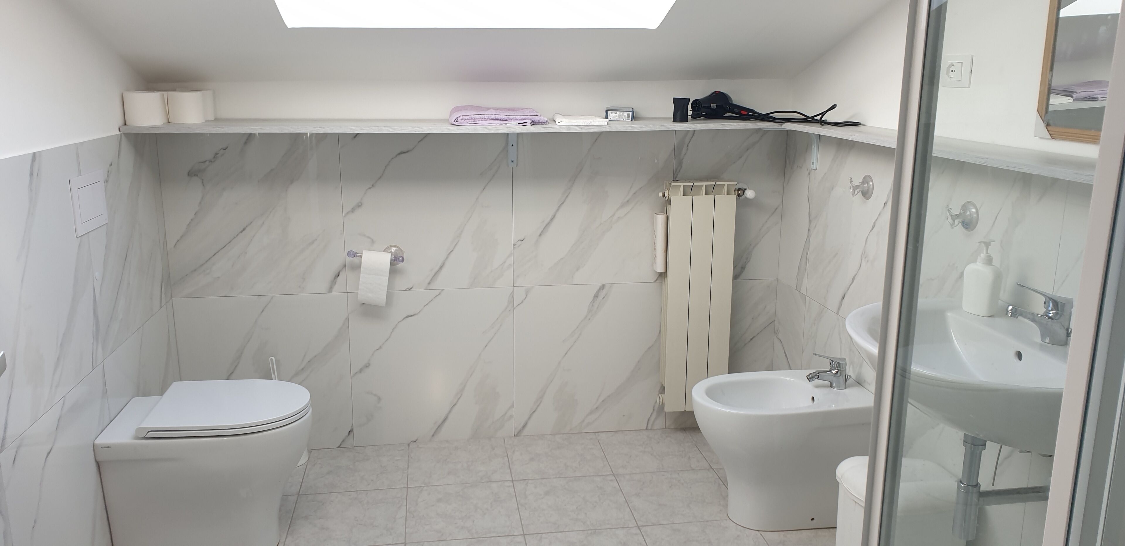 A compact bathroom with a toilet, bidet, and sink.