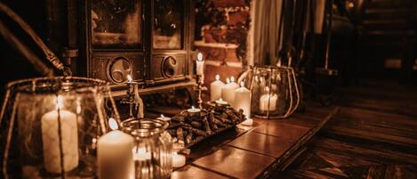 A wooden table with candles and a vintage radio.