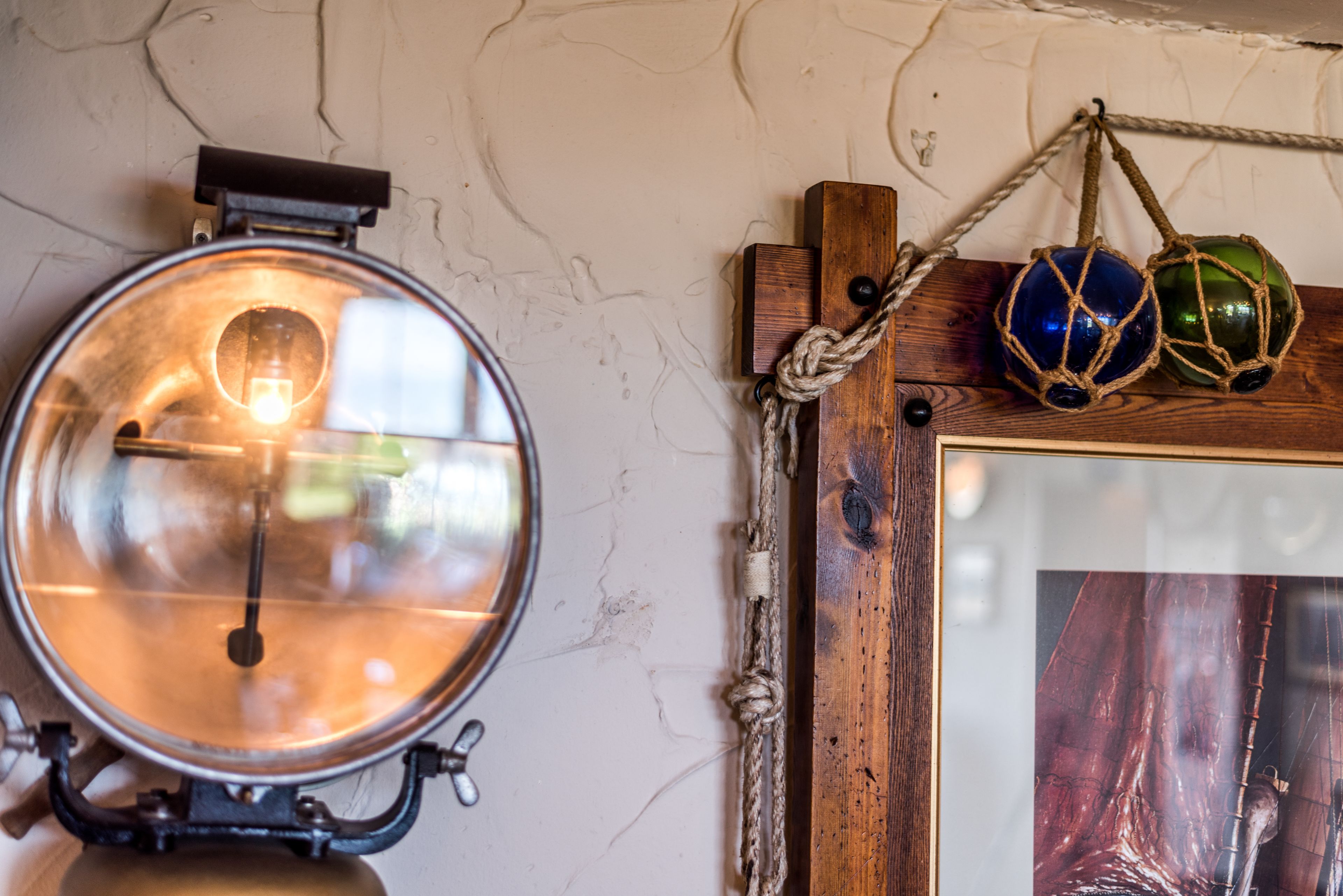A vintage wall clock, a framed artwork, and two spherical ornaments on a wooden shelf.