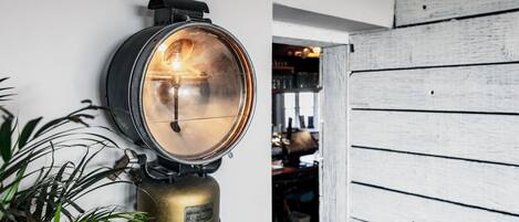 A wall-mounted light fixture with a brass base and a circular glass cover.