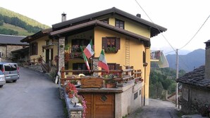 A yellow building with a wooden door and a sign reading "POSTO TAPPA". - La Tano Di Grich (Prazzo)