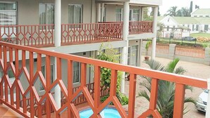 Un immeuble à plusieurs étages doté de balcons, d’un sol carrelé et d’une piscine.