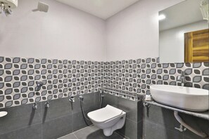A modern bathroom with a toilet, bidet, and sink. - Hotel Maryland by Sky Stays (Vadodara)