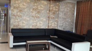 A modern living room with a sectional sofa, a coffee table, and a decorative wall.