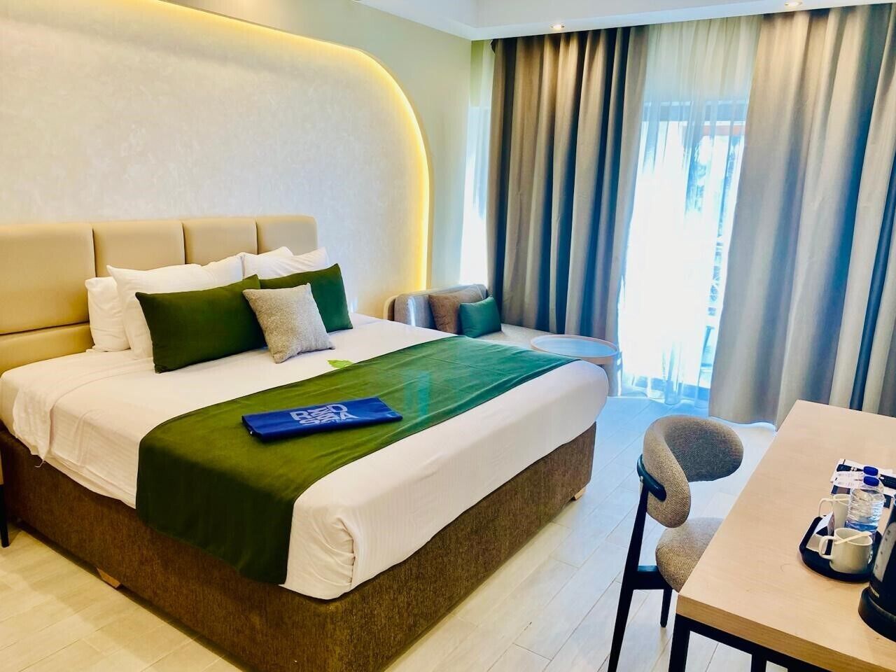 A hotel room with a bed, a desk, and a chair.