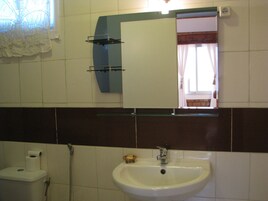 Un baño con inodoro, lavabo y espejo.