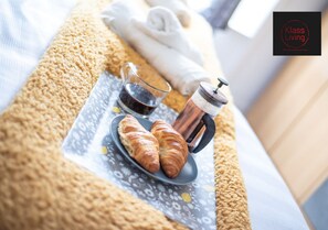 A breakfast setup with croissants, a coffee pot, and a cup on a tray. - One Bedroom Apartment by Klass Living Serviced Accommodation Coatbridge - Albion Apartment with Wifi and Parking (Coatbridge)