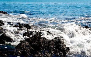 A rocky shoreline with waves crashing against the rocks.