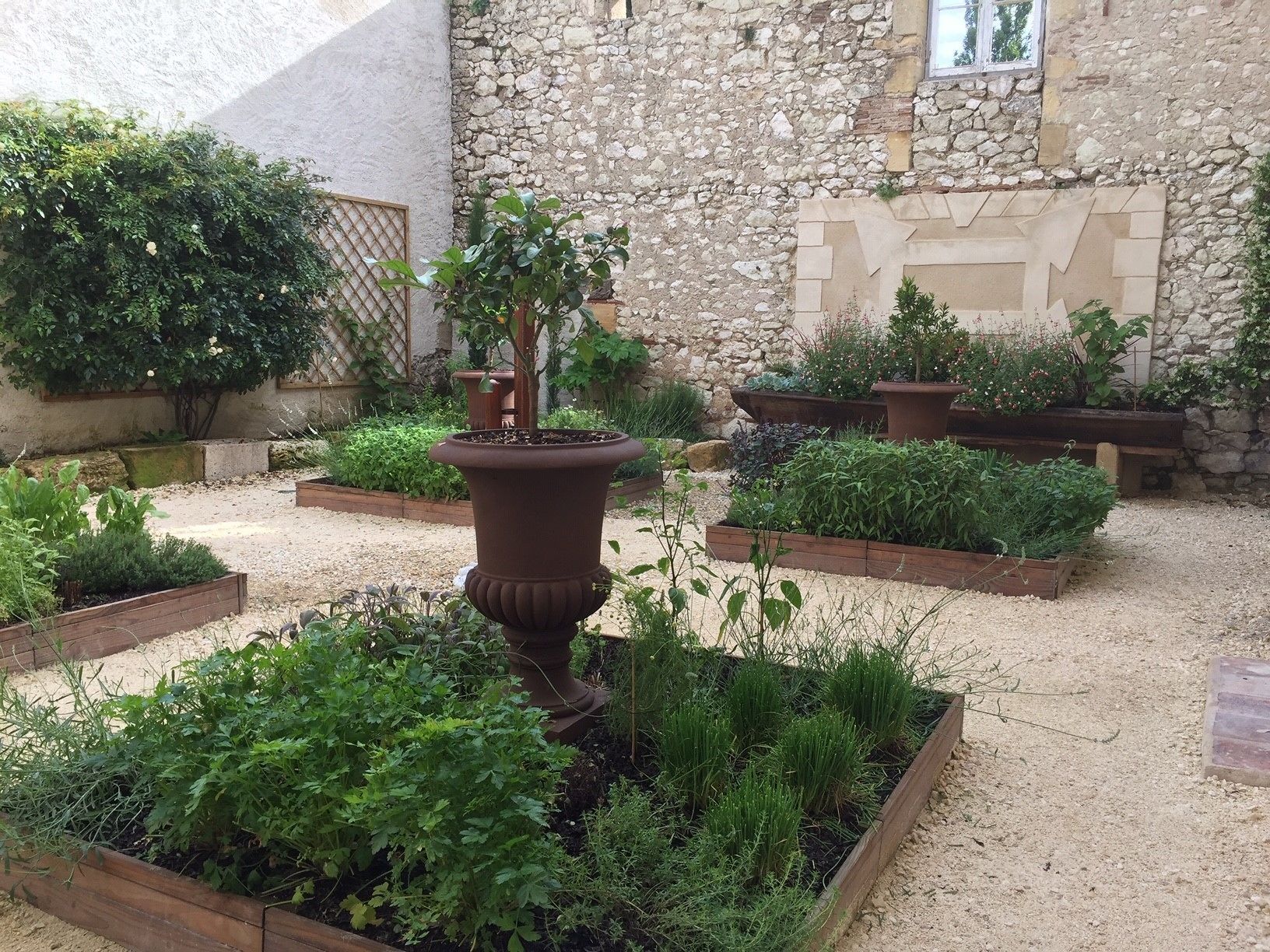 A garden with raised beds and a central planter.