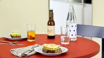 A dining table with a sandwich, a bottle, and glasses.