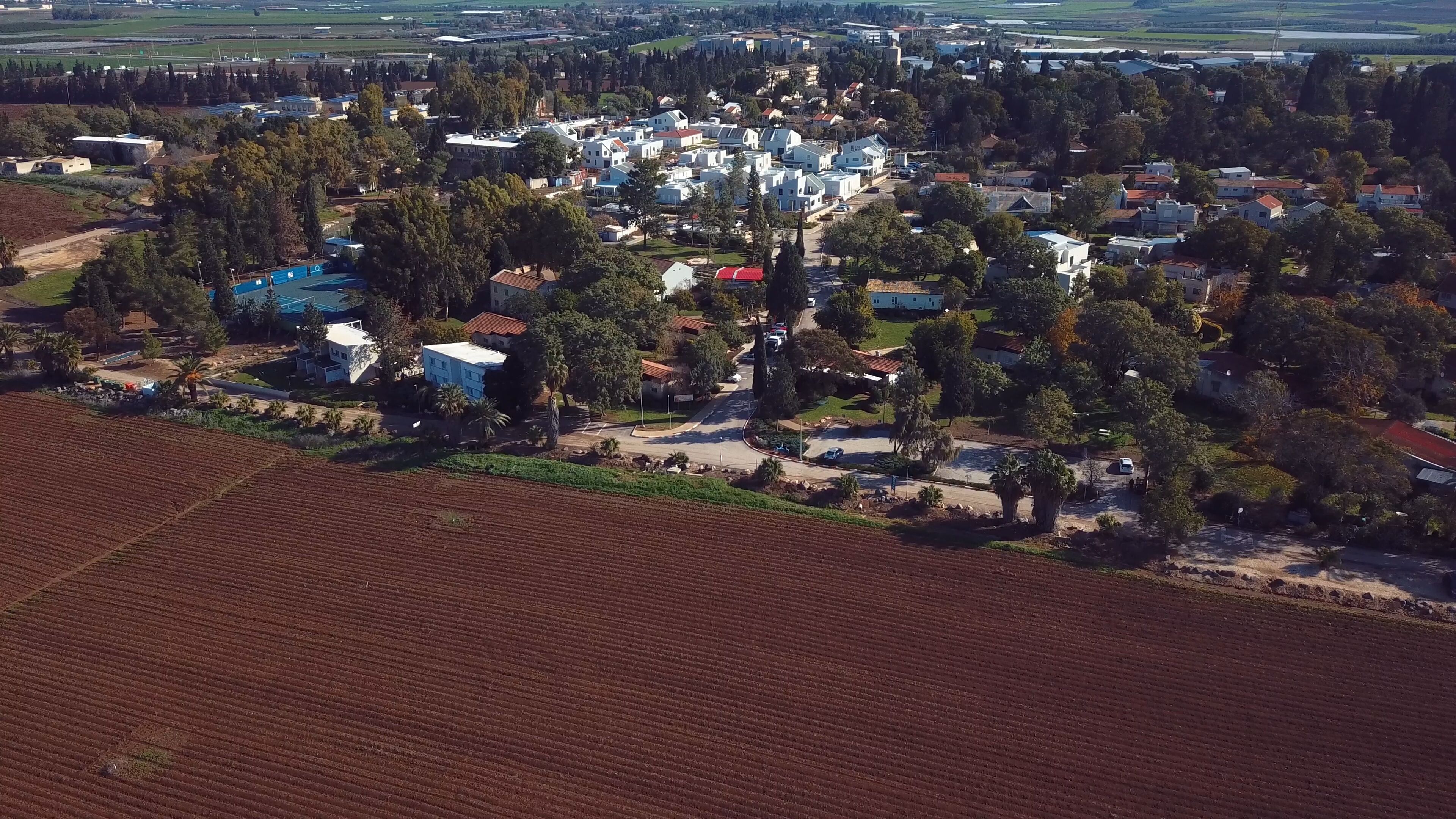 Luchtbeeld van een woongebied met huizen, wegen en velden.