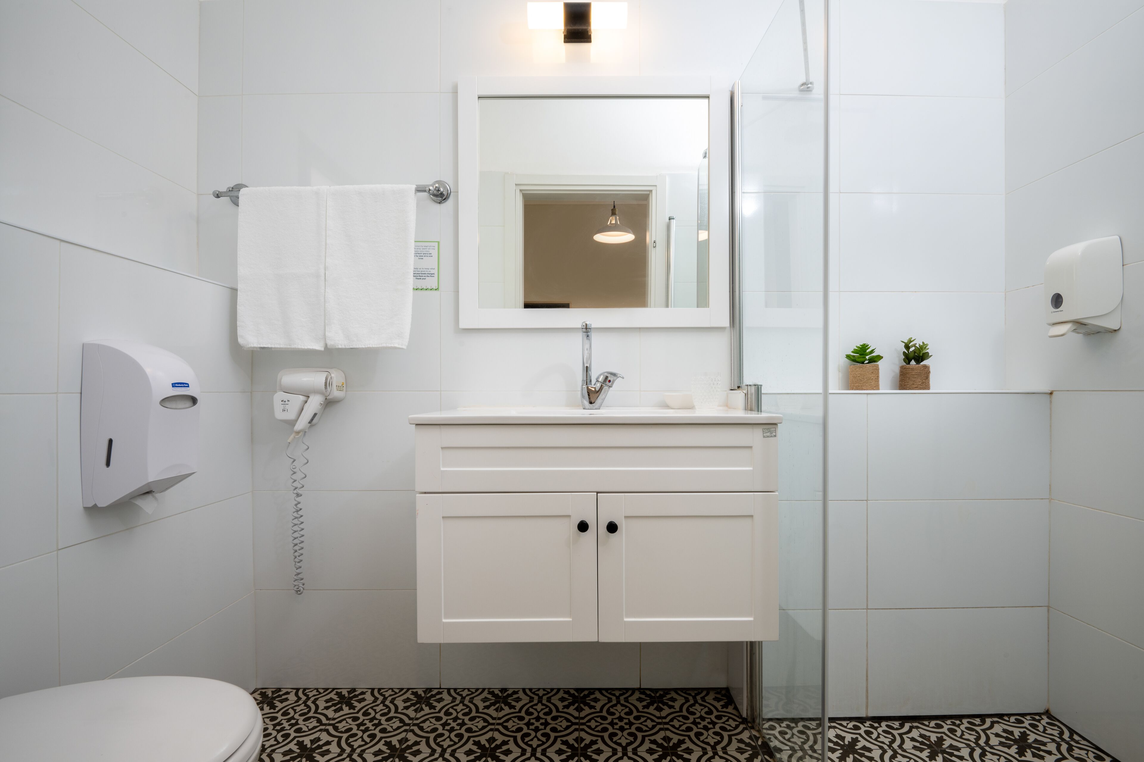 Une salle de bain moderne avec un lavabo blanc, un miroir et des toilettes.