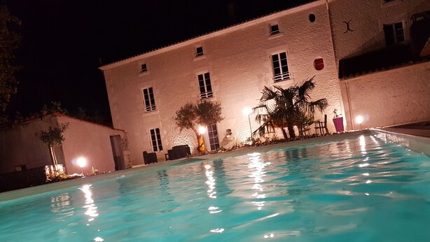 Ein Schwimmbad mit einem weißen Gebäude im Hintergrund.