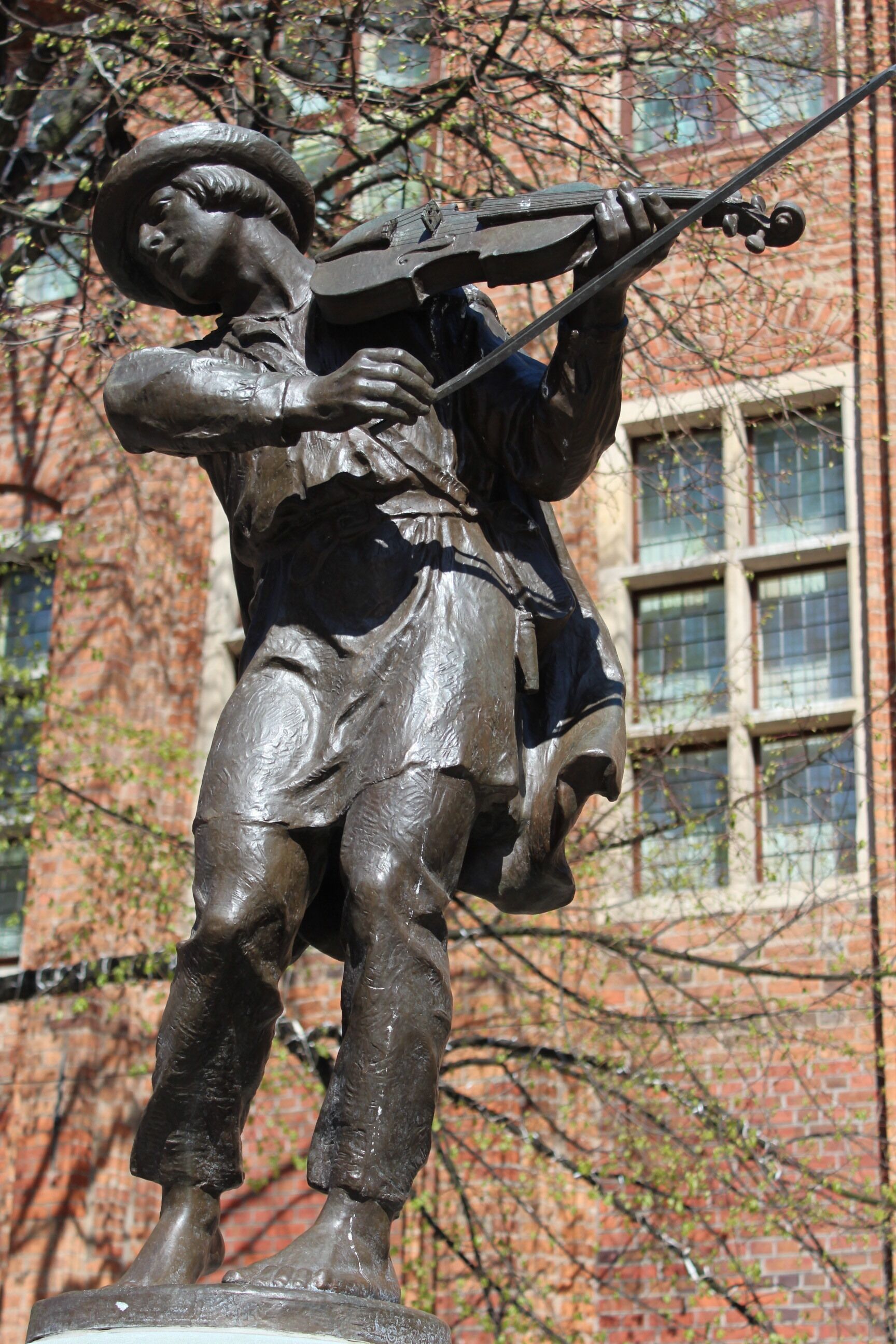 A bronze statue of a person playing a violin.