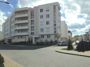 A multi-story building with a flat facade, several balconies, and a sign indicating it is a hotel. - Apartament Torun (Torun)