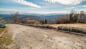 Un sendero de grava que lleva a un edificio con vistas a montañas distantes.