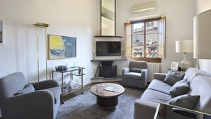 Uma sala de estar moderna com sofá, poltronas, mesa de centro, televisão e lareira.