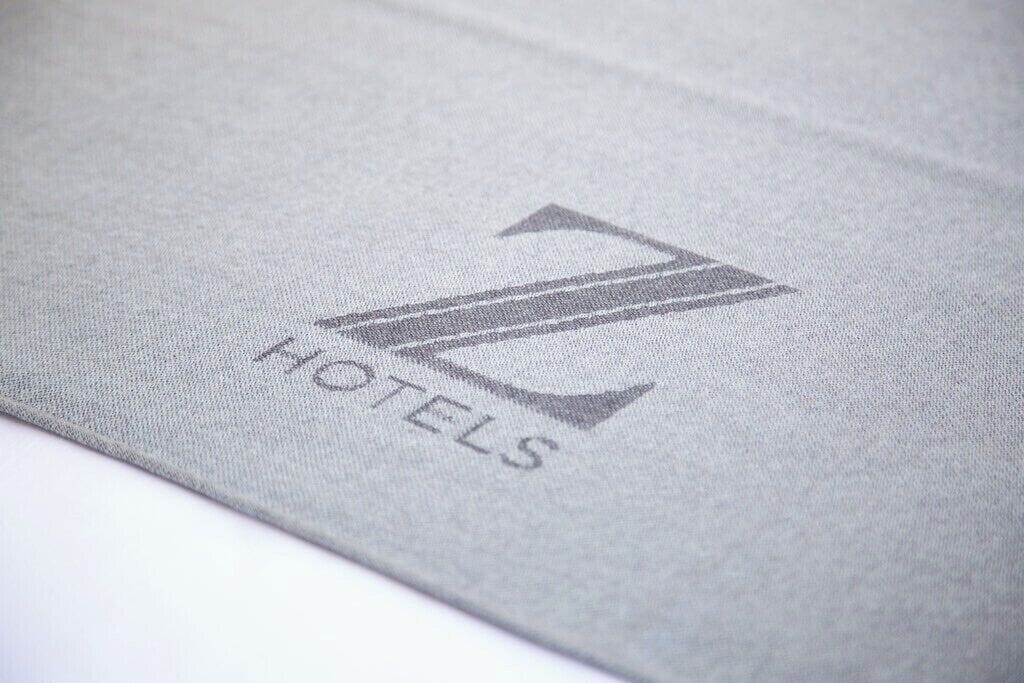 A close-up of a fabric with a logo and the word "HOTELS" visible.