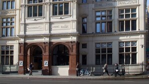 En bygning med skilt der siger "Dining Rooms", en stor buet indgang og en cykel foran.
