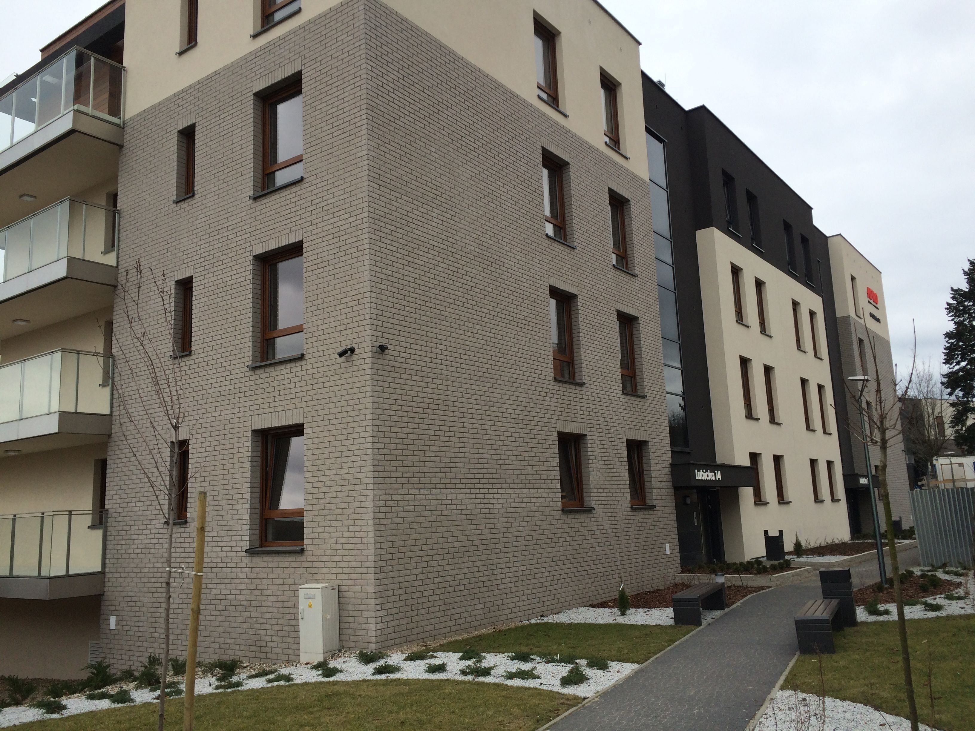 A multi-story building with a brick facade, a balcony on the left, and a sign indicating the name 'Rubik's 14'.