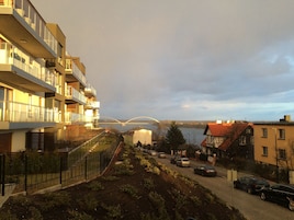 Zona residencial con edificios de apartamentos modernos, un camino pavimentado y coches estacionados.