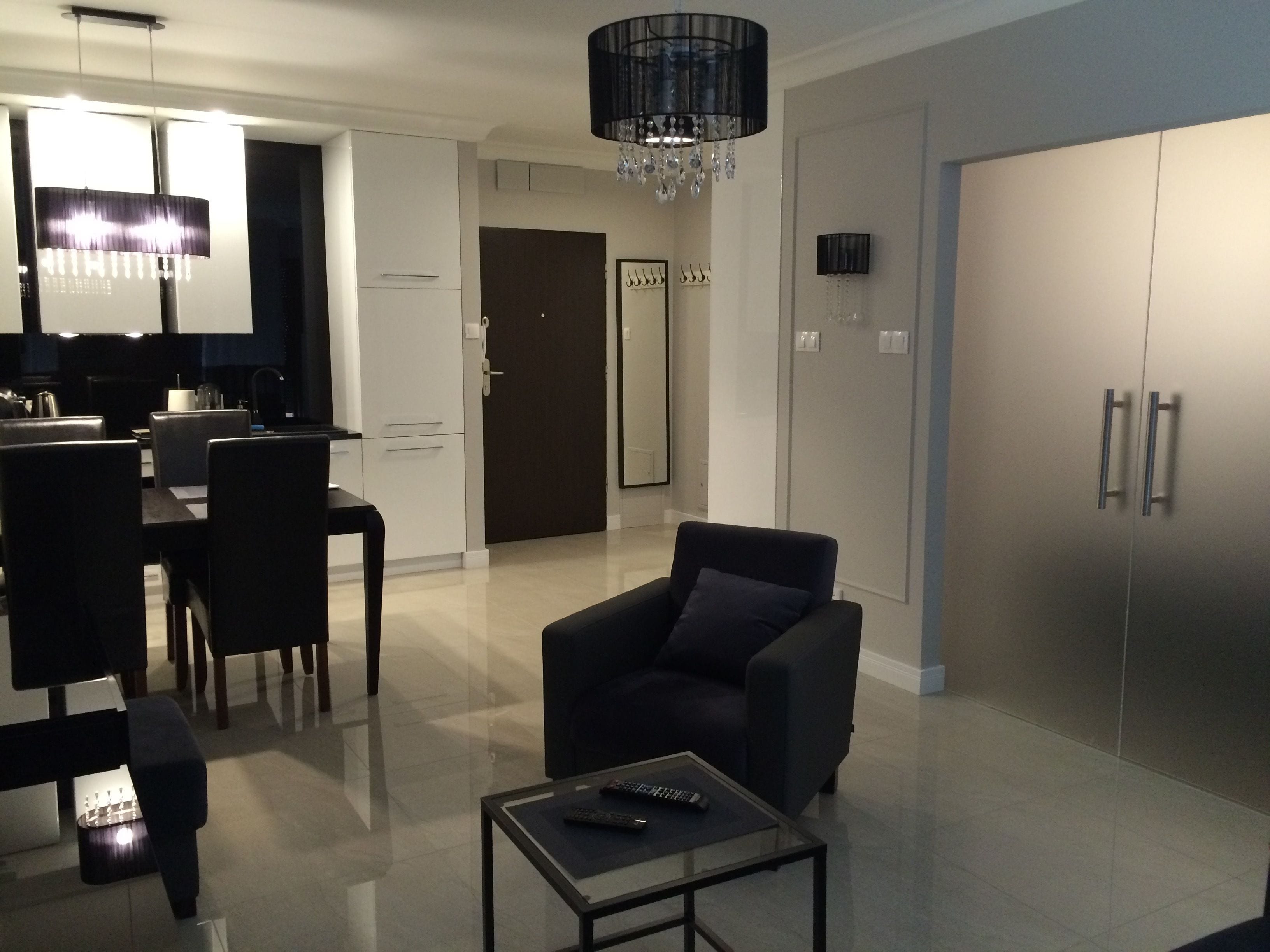 A modern living room with a sofa, a coffee table, and a dining area with chairs and a table.
