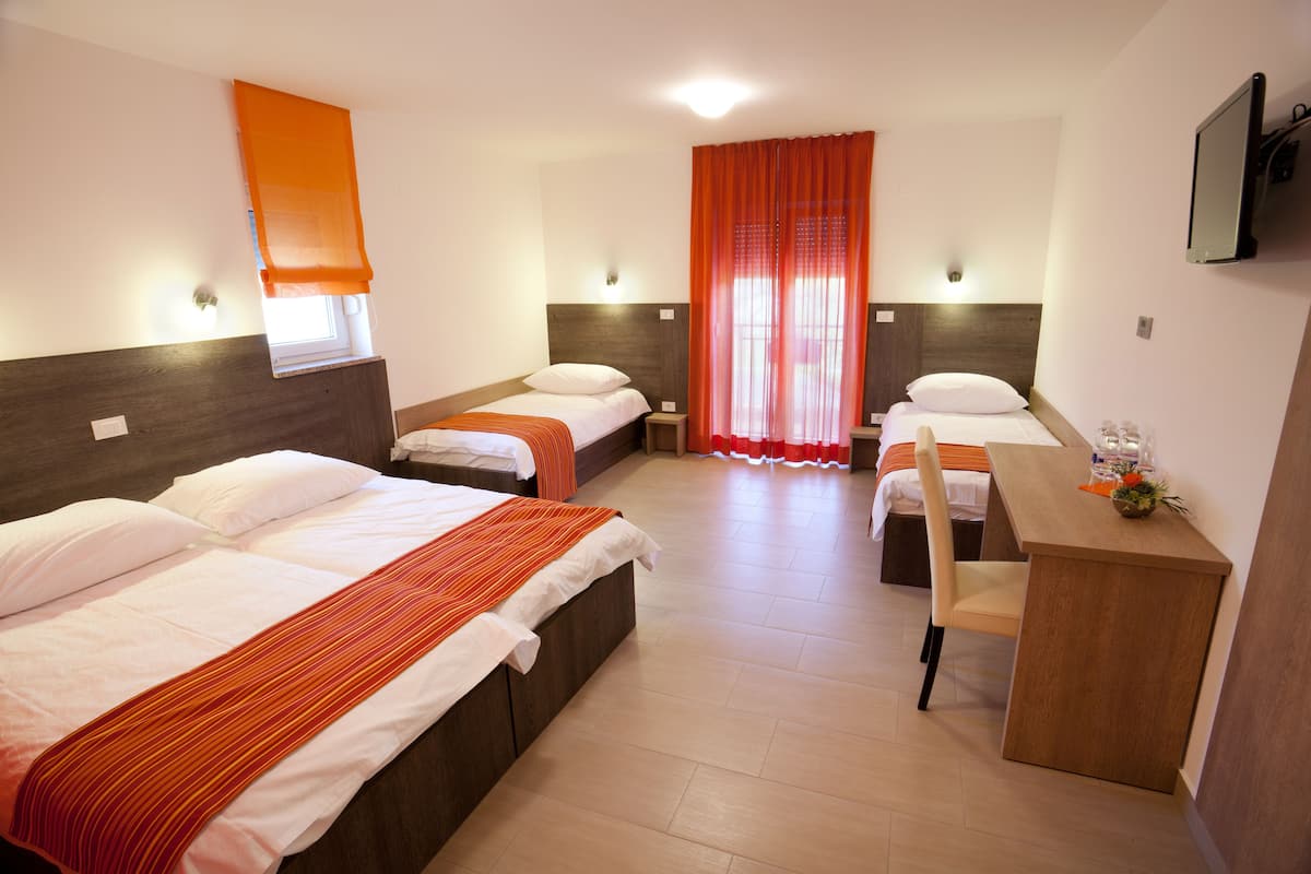 Une chambre d’hôtel avec deux lits, un bureau et une chaise.