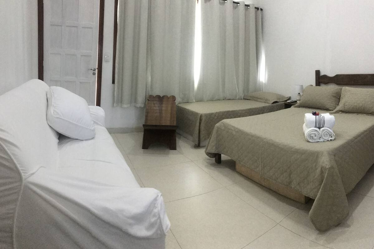 Una habitación de hotel con cama, sofá y una pequeña mesa de madera.