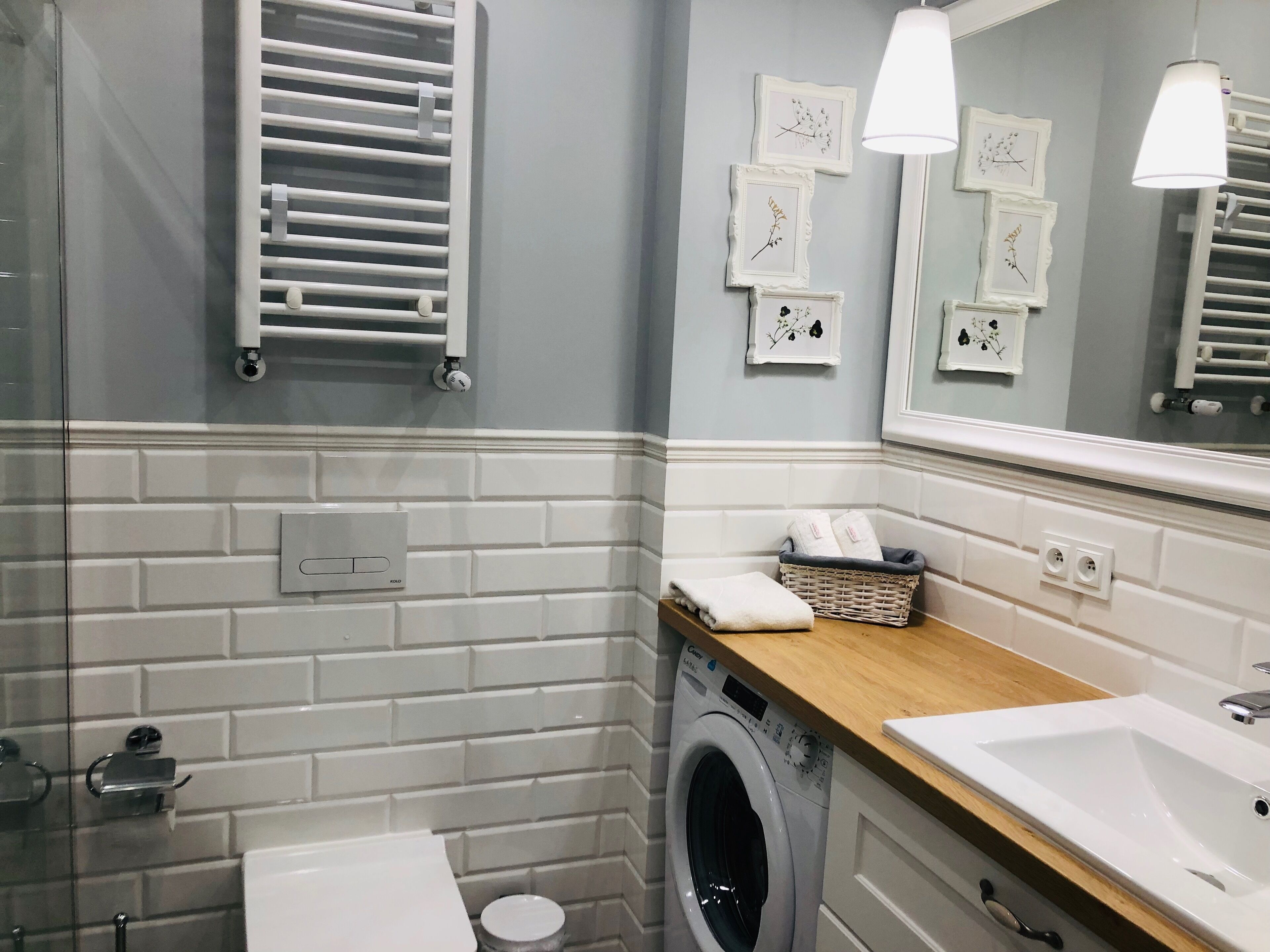 Un baño moderno con lavadora integrada, un lavamanos y un espejo.
