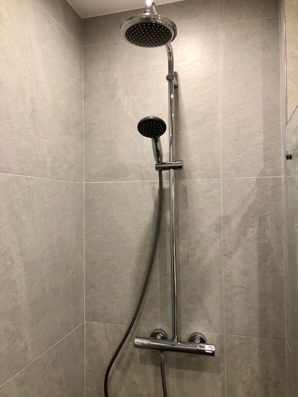 A shower with a handheld showerhead and a fixed showerhead mounted on a wall. - OldTown deLuxe (Torun)